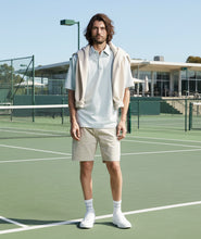 Load image into Gallery viewer, Man wearing a light green shirt, beige shorts, and white sneakers on a white background