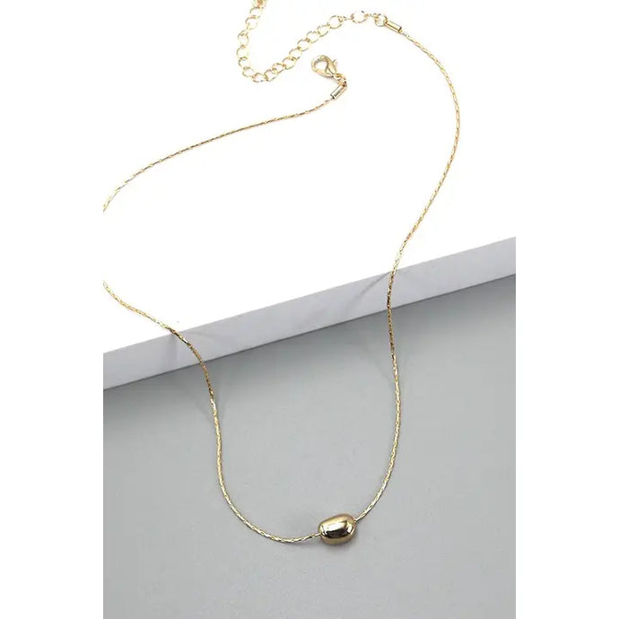 gold necklace with bean charm