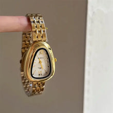 Load image into Gallery viewer, A gold-tone women's watch with a unique rounded triangular case and a white dial.
