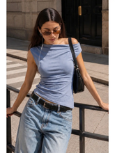 Load image into Gallery viewer, A woman wearing a light blue off-the-shoulder fitted top.
