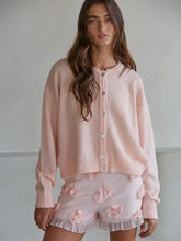 Load image into Gallery viewer, Woman wearing a pink cardigan and matching shorts with floral details against a neutral background
