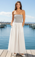 Load image into Gallery viewer, Woman wearing a strapless black and white striped dress on a plain background
